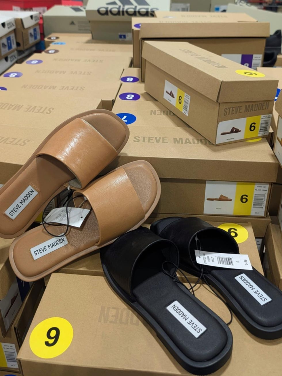 Des sandales pour femme beiges et noires de marque Steve Madden vendues dans le rayon des v\u00eatements chez Costco.