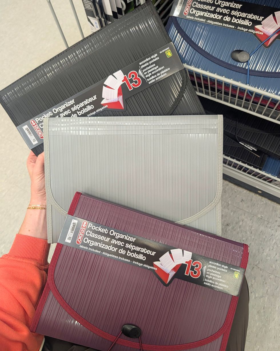 Des \u200bclasseurs avec s\u00e9parateurs bleu, noir, gris et rouge vendus dans la rang\u00e9e des fournitures scolaires chez Dollarama.
