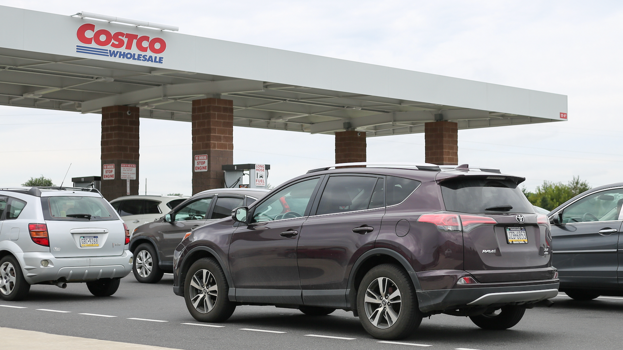 Des véhicules attendent en ligne devant une station d'essence Costco.