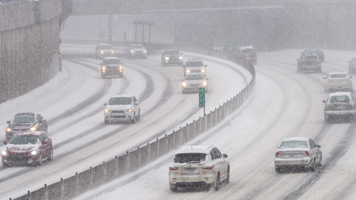 Des véhicules circulent sur une autoroute enneigée à Montréal.