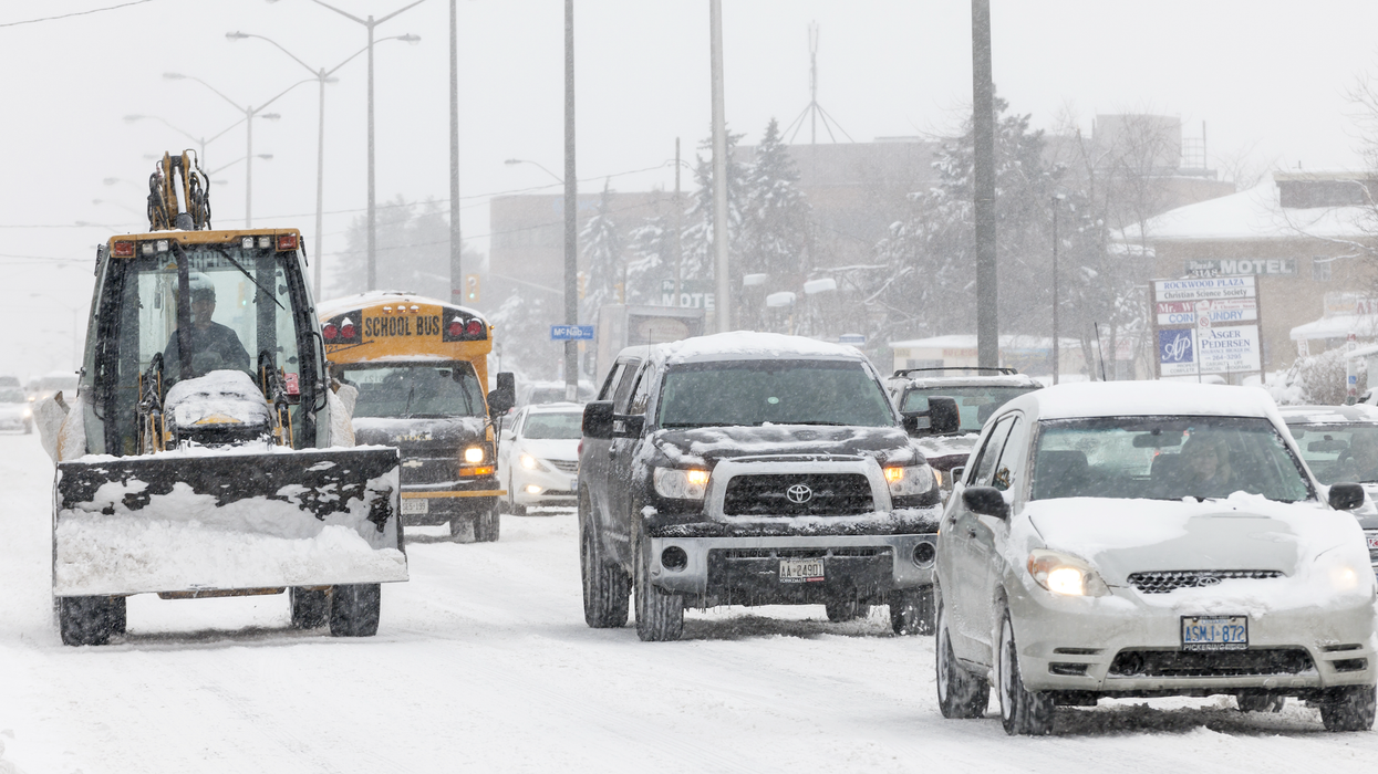 Des véhicules circulent sur une route enneigée au Canada.