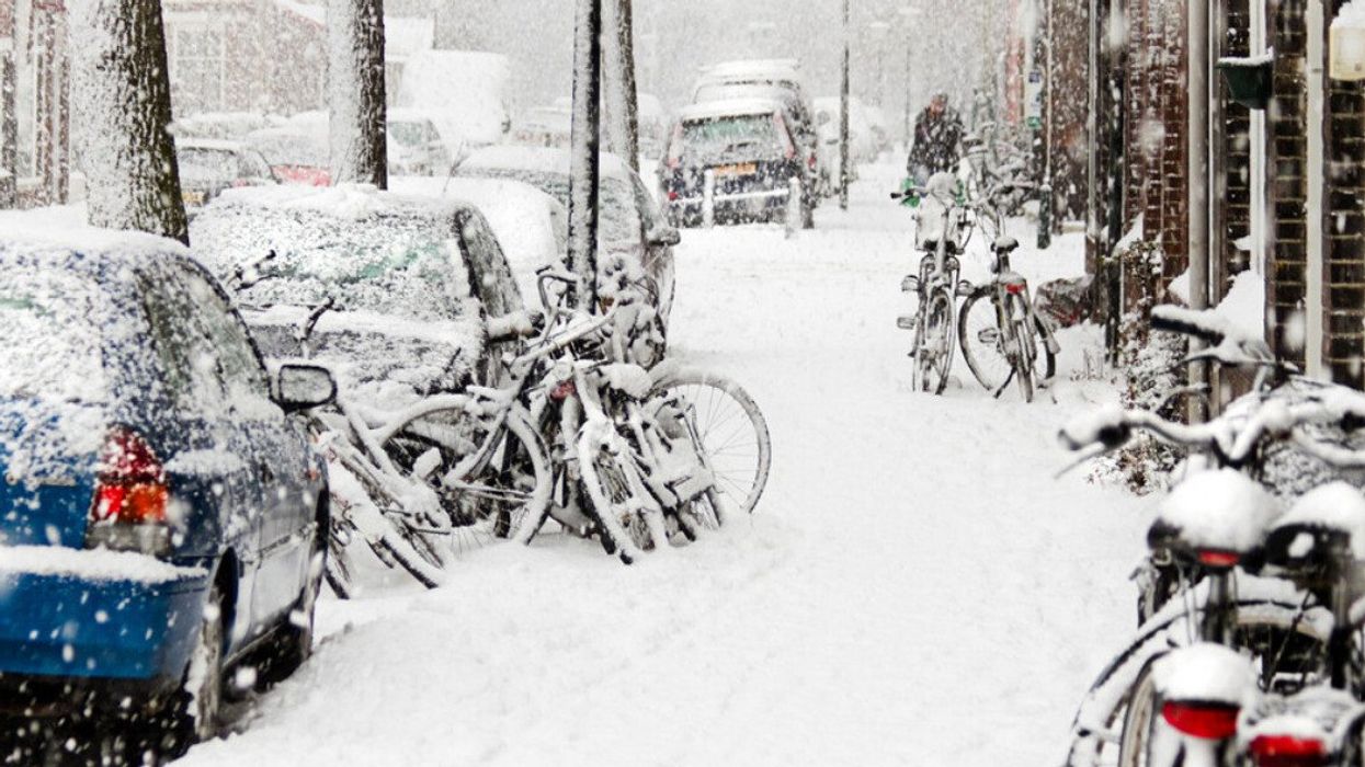 Des voitures et des vélos sous la neige.