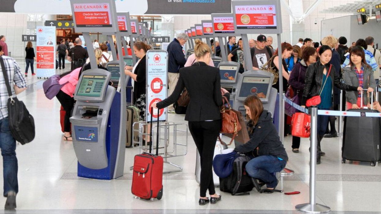 Des voyageurs aux guichets d'enregistrement d'Air Canada.