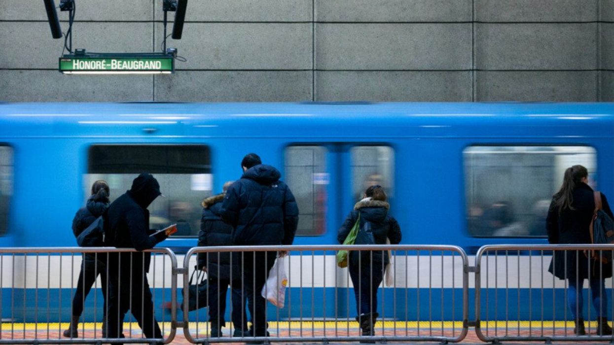 Des wagons du métro de Montréal circulent devant des passagers sur un quai.