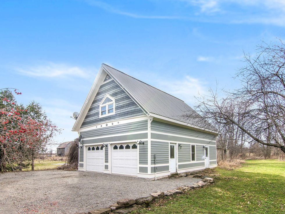 Detatched garage surrounded by trees.