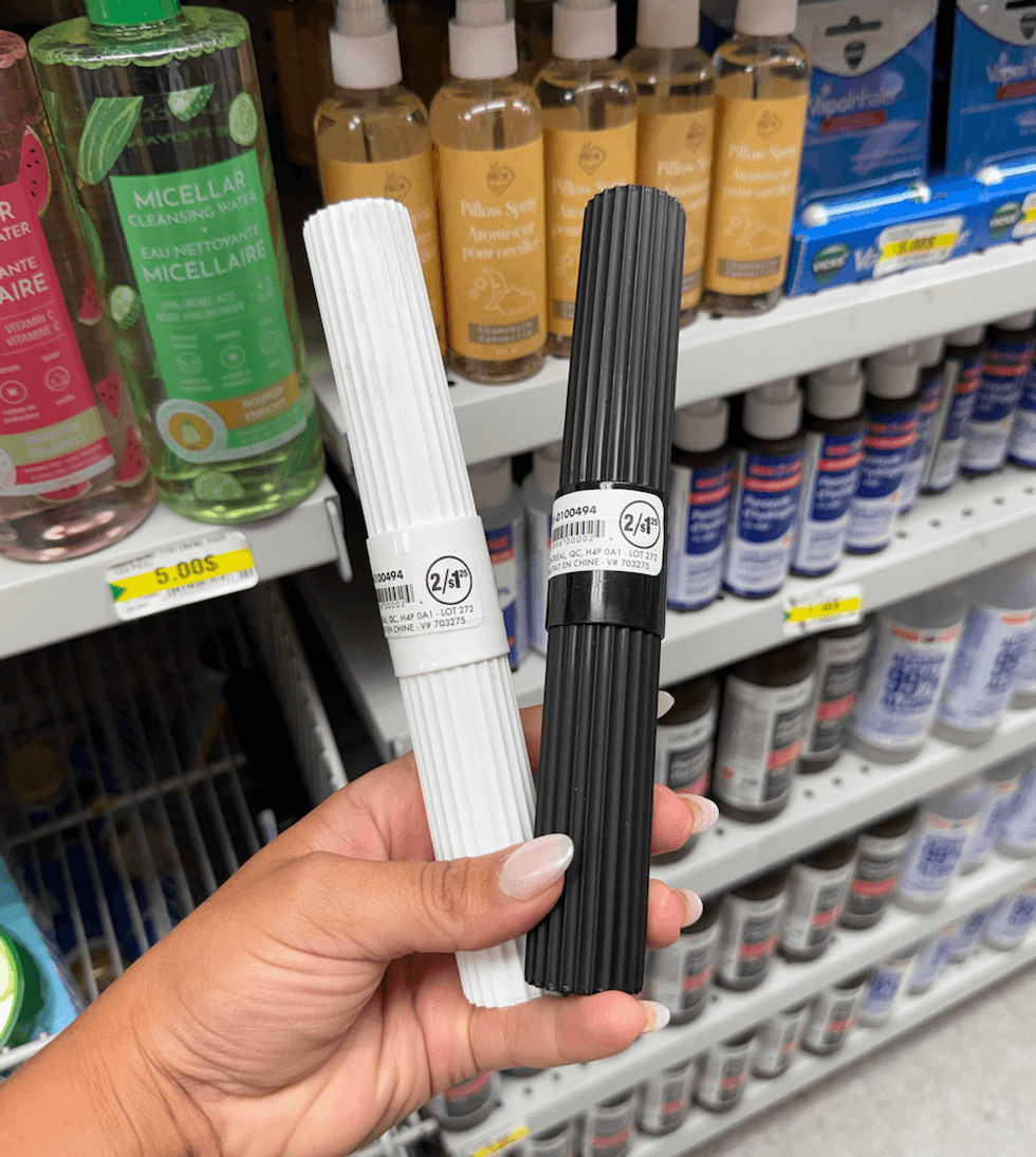 Deux bo\u00eetiers \u00e0 brosse \u00e0 dents, un noir et un blanc, en plastique dans une main.