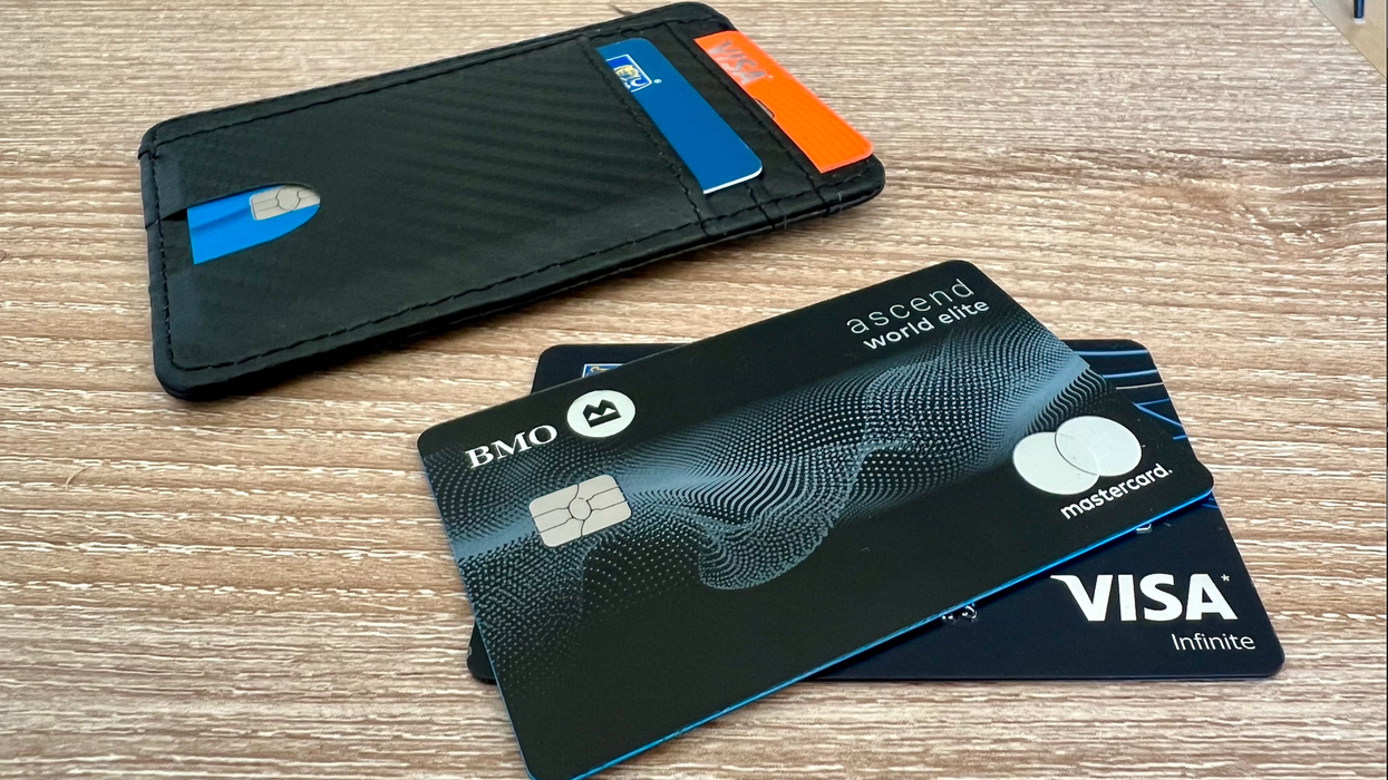 Deux cartes de crédit noires sont étalées à côté d'un porte-cartes noir sur une table.