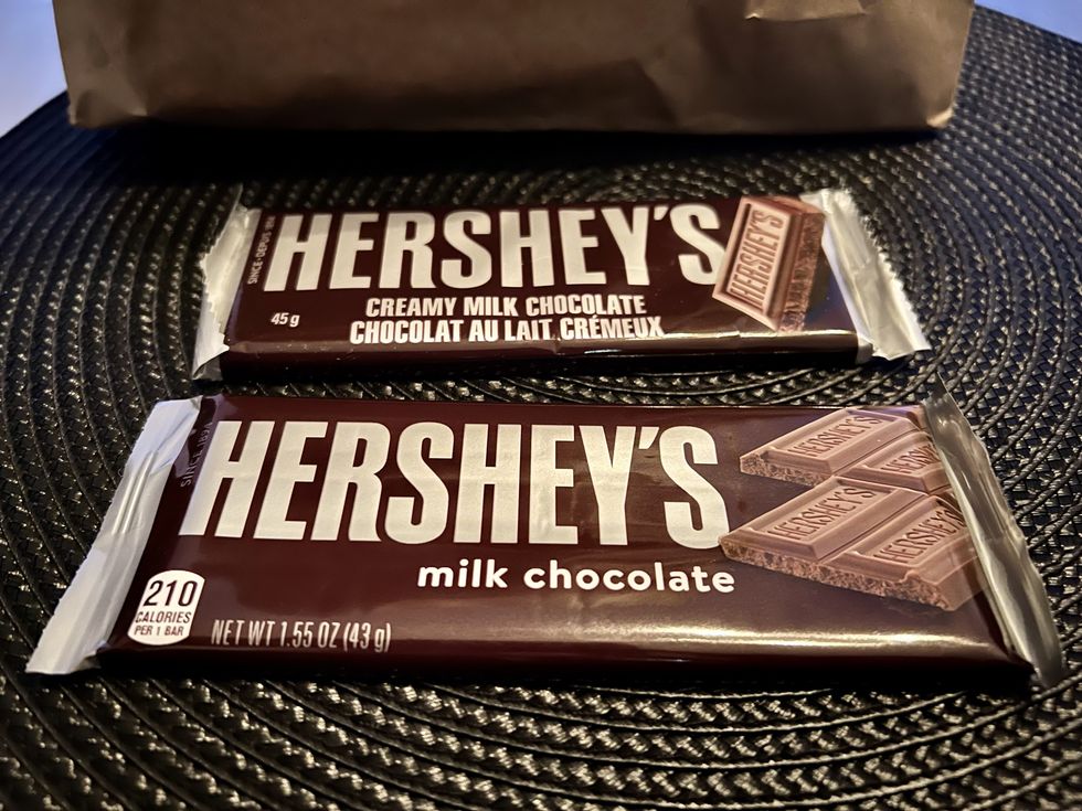 Deux emballages de Hershey's chocolat au lait sont plac\u00e9s sur un napperon rond noir.