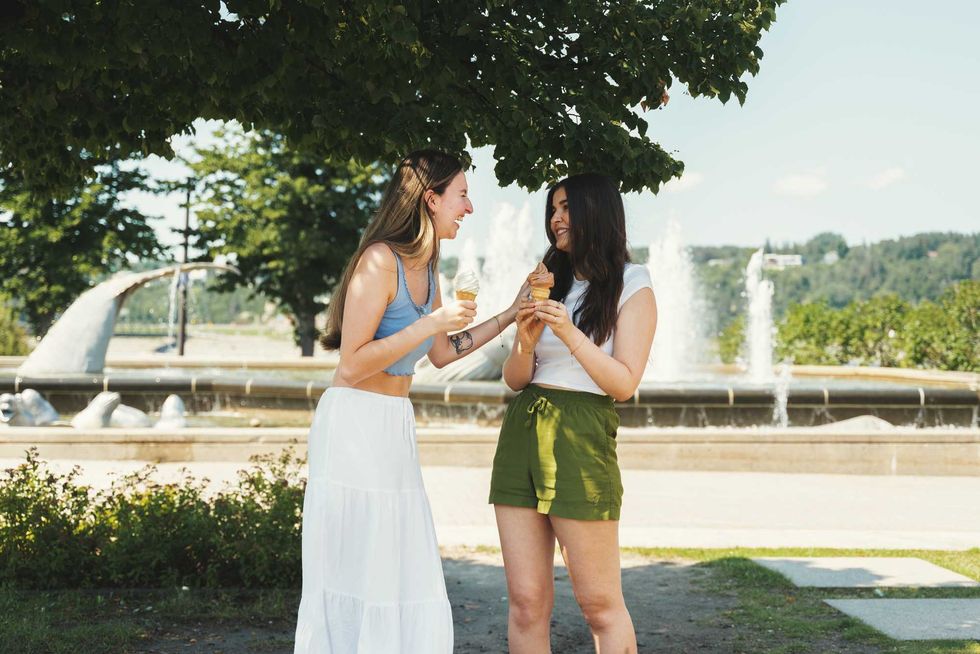 Deux personnes d\u00e9gustent une cr\u00e8me glac\u00e9e devant une fontaine au Qu\u00e9bec.