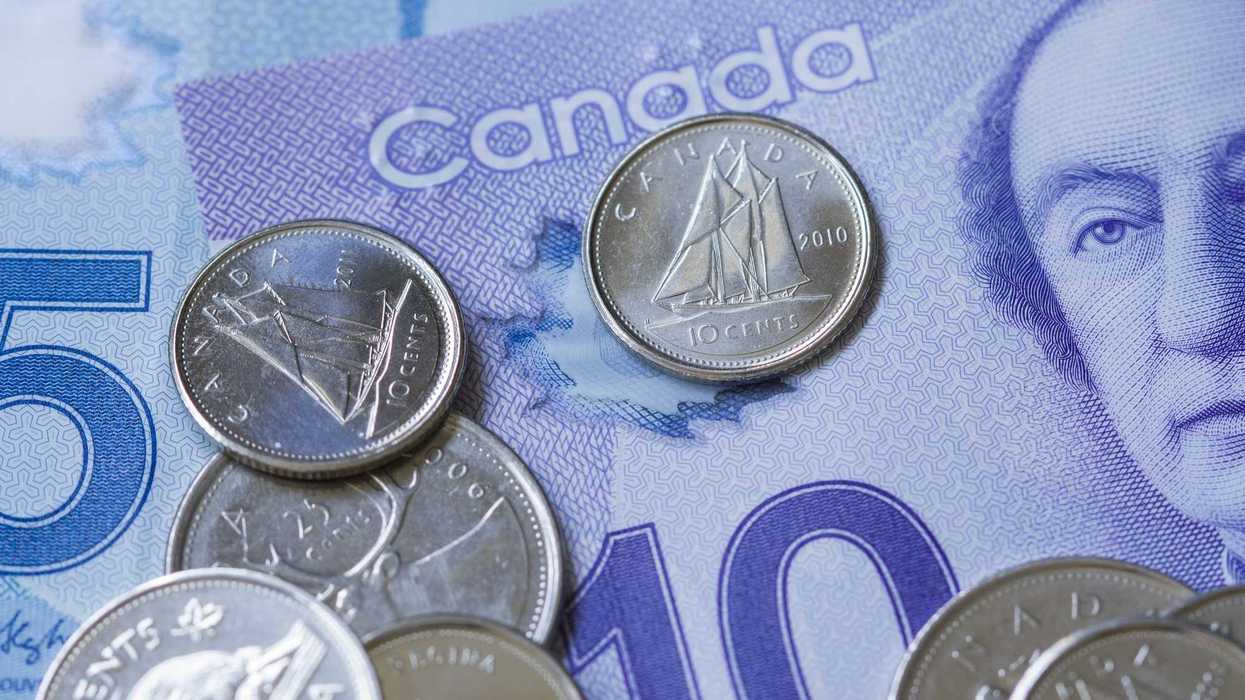 dimes and other canadian coins on top of canadian banknotes
