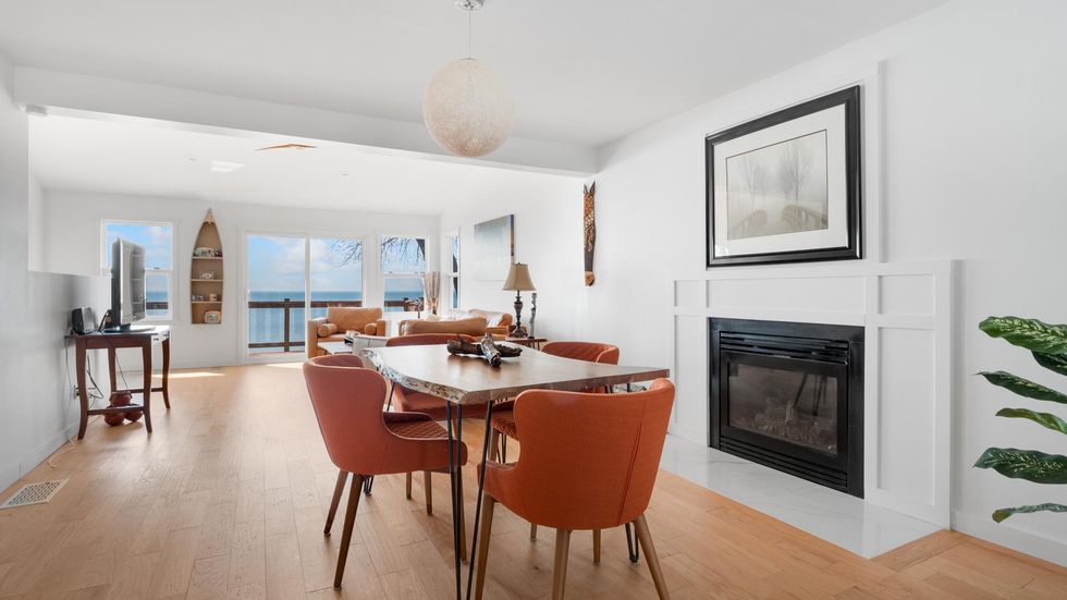Dining area with a fireplace and water views.