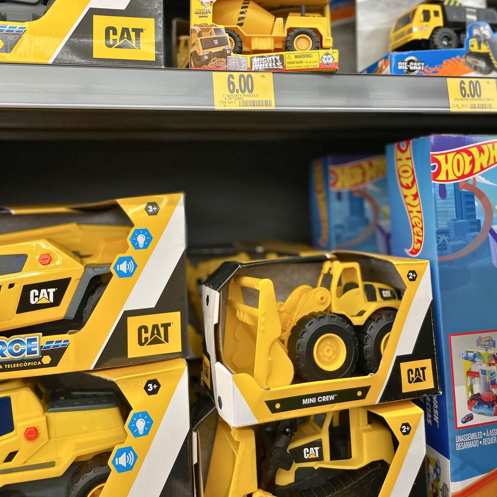 Divers jouets camion dispos\u00e9s sur les \u00e9tag\u00e8res d'un magasin.