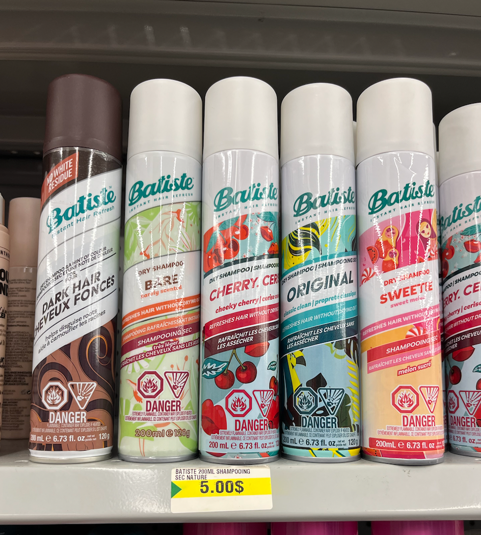 Diverses bouteilles de shampoing sec Batiste sur les tablettes du Dollarama.