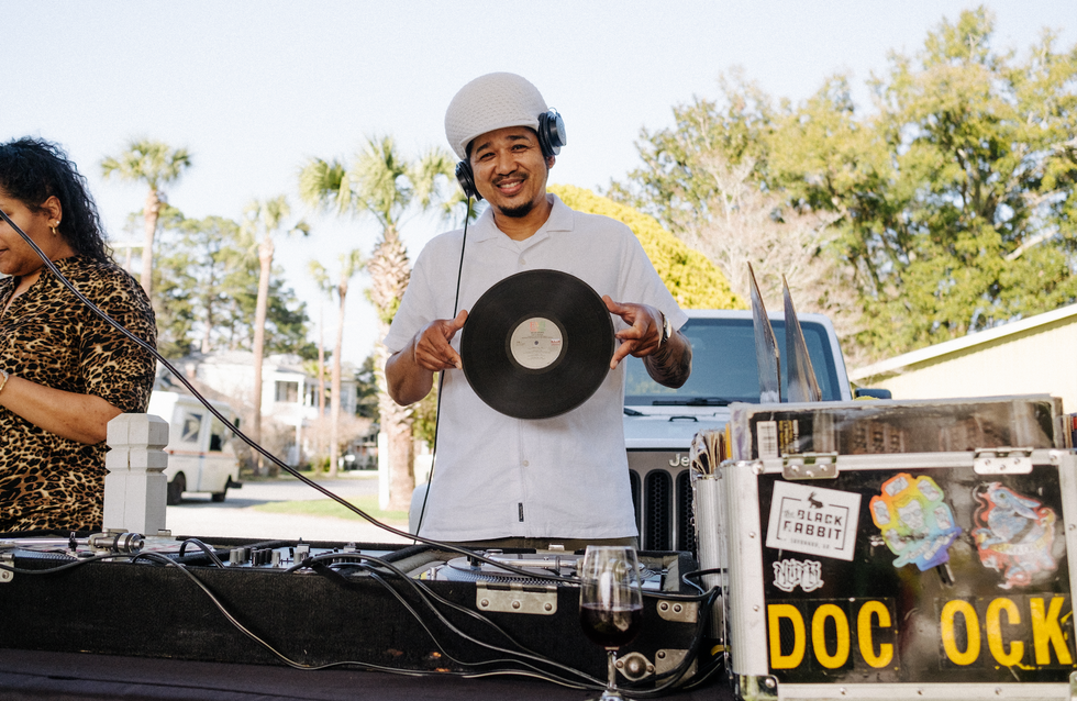DJ dock ock holding up a vinyl record.