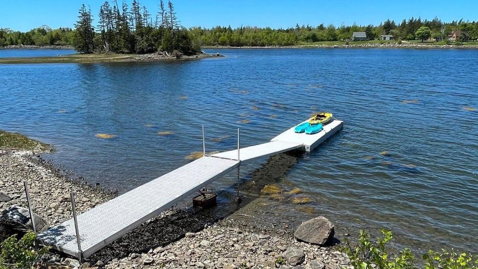 Dock on the water with the private island in the distance.