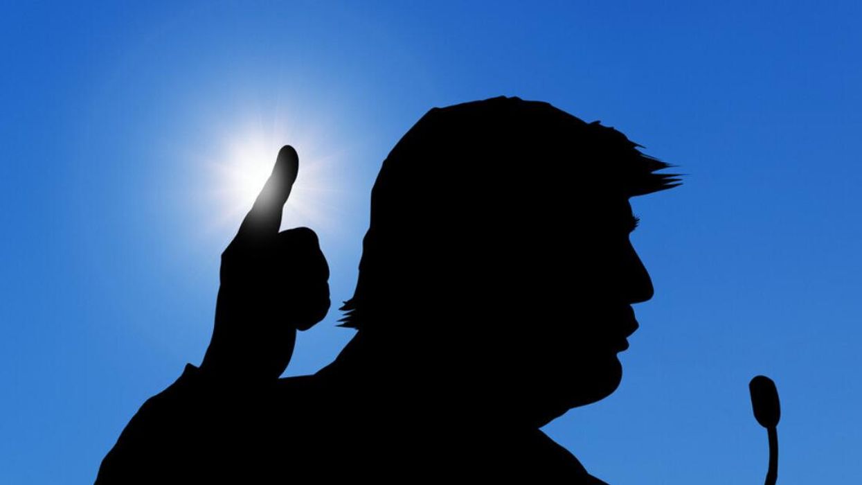 Donald Trump shown in silhouette while speaking at a news conference.