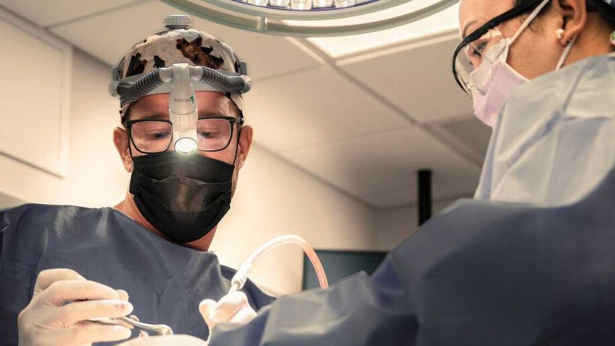 Dr. Cory Torgerson performs surgery in an operating room assisted by a nurse.