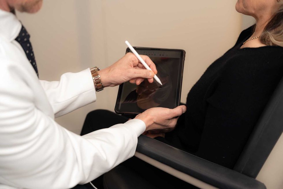 Dr. Cory Torgerson uses an iPad to demonstrate surgical options to a patient at his clinic in Toronto.