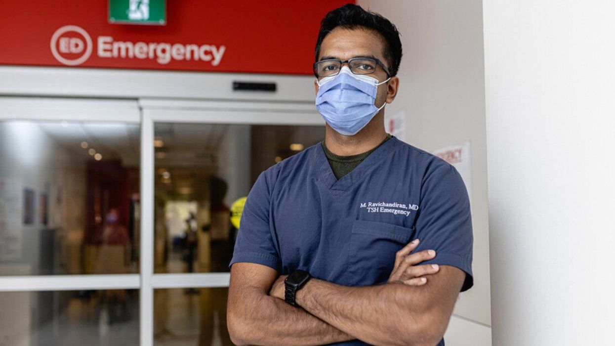 Dr. Mayoorendra Ravichandiran stands with arms crossed in front of the emergency entrance to the hospital.