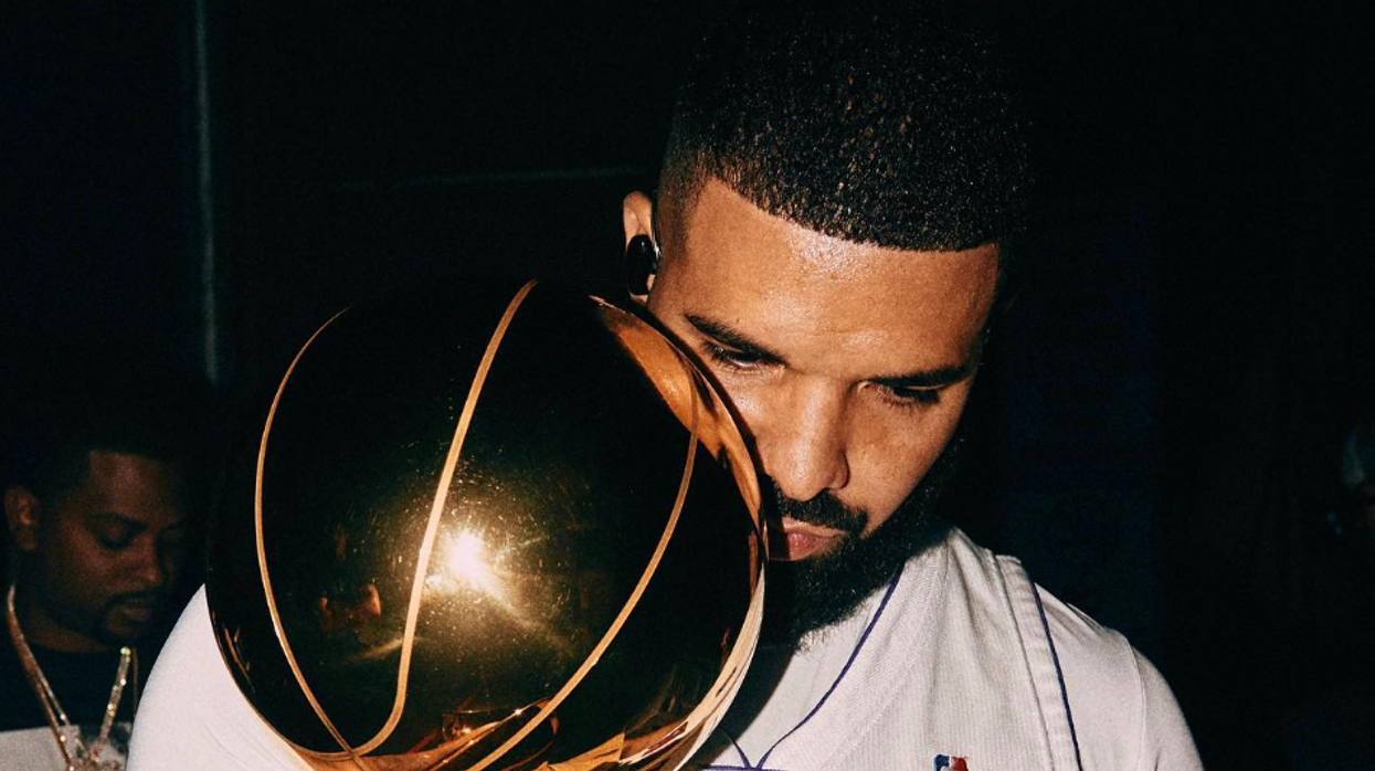 Drake holding the NBA trophy.