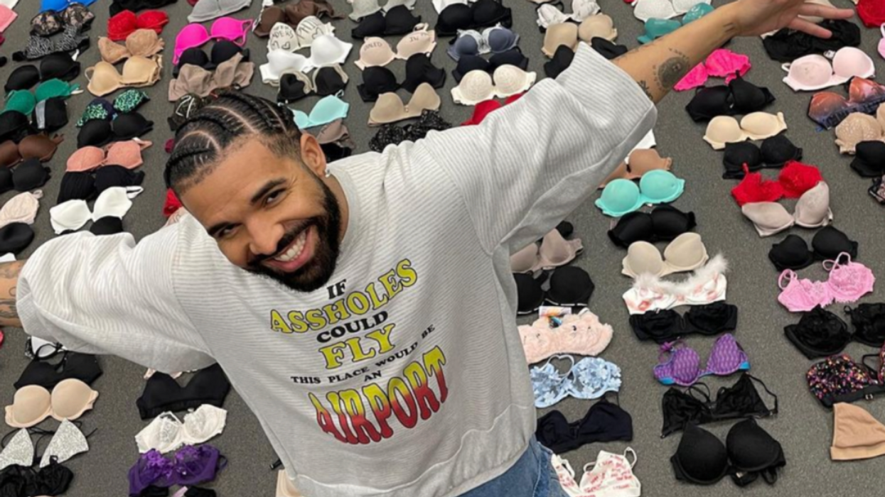 Drake standing in front of rows of bras.