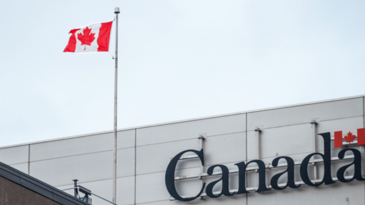 Drapeau canadien au vent devant un établissement fédéral.