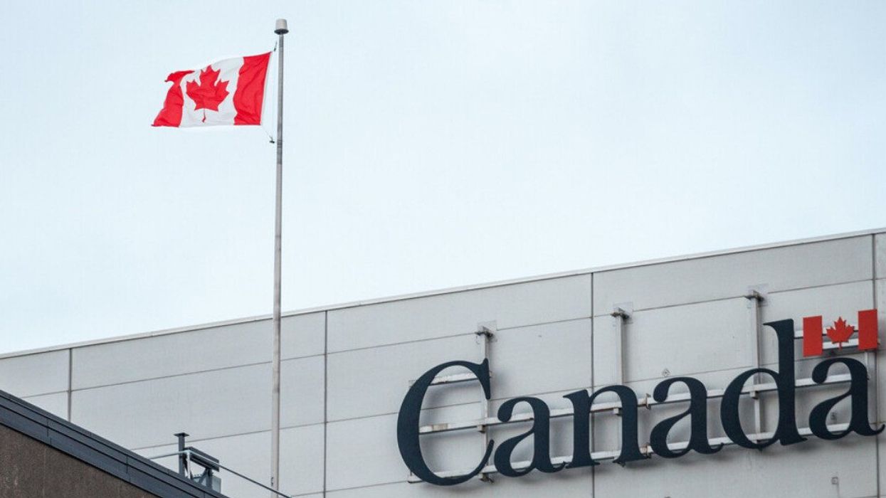 Drapeau et signe du Canada sur un édifice du gouvernement.