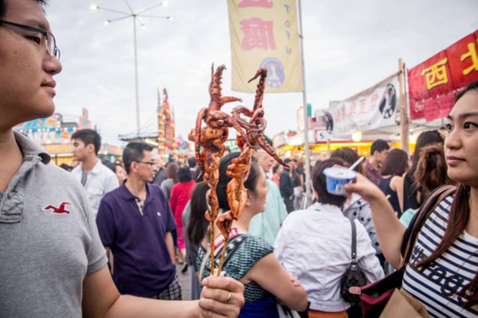 Eating BBQ squid skewers at a Chinatown Night Market in Ottawa.