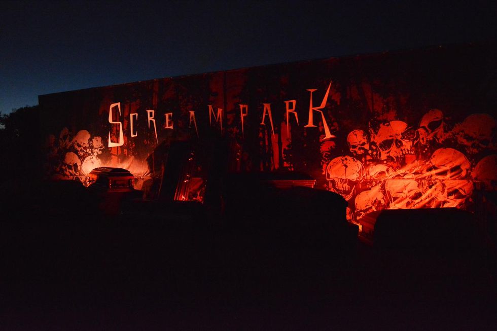 Eerie Screampark sign with skulls, lit up in the dark.