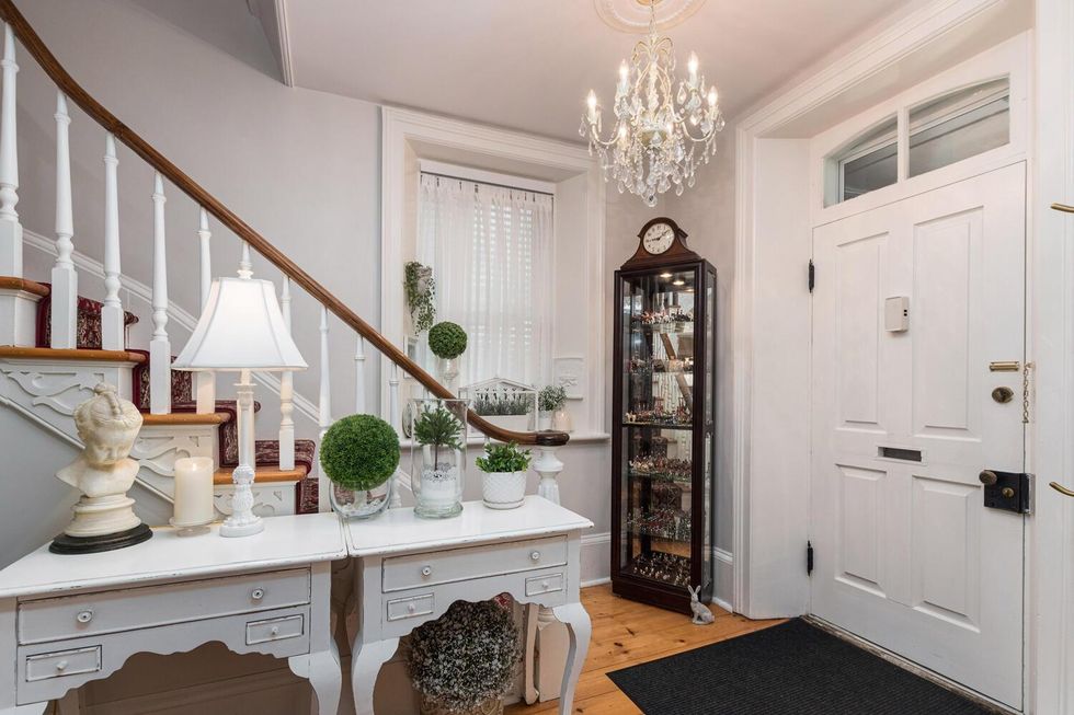 Entranceway with a chandelier and curving staircase.