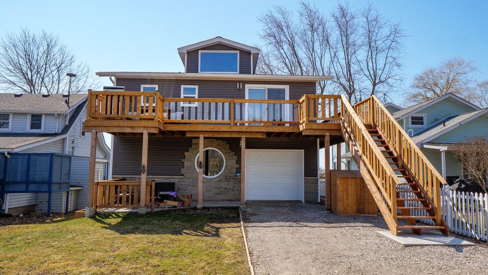 Exterior of a two-storey home with a wraparound deck.