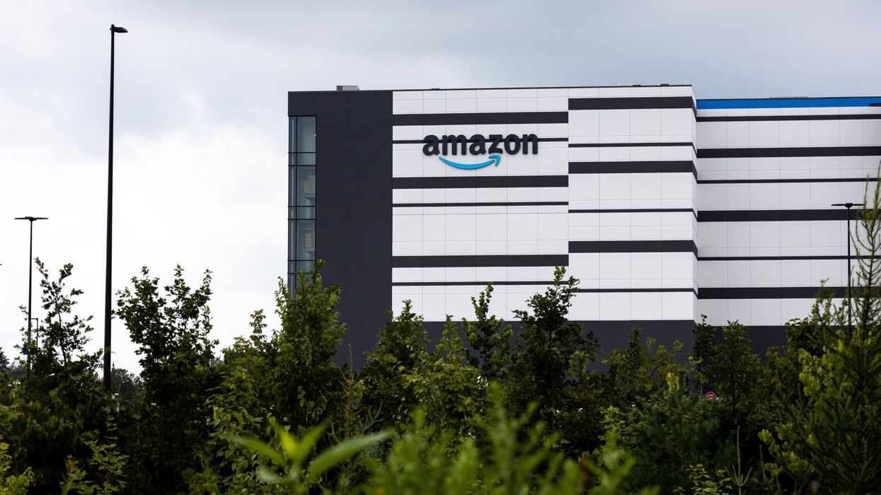 Exterior of an Amazon warehouse with trees in the foreground.