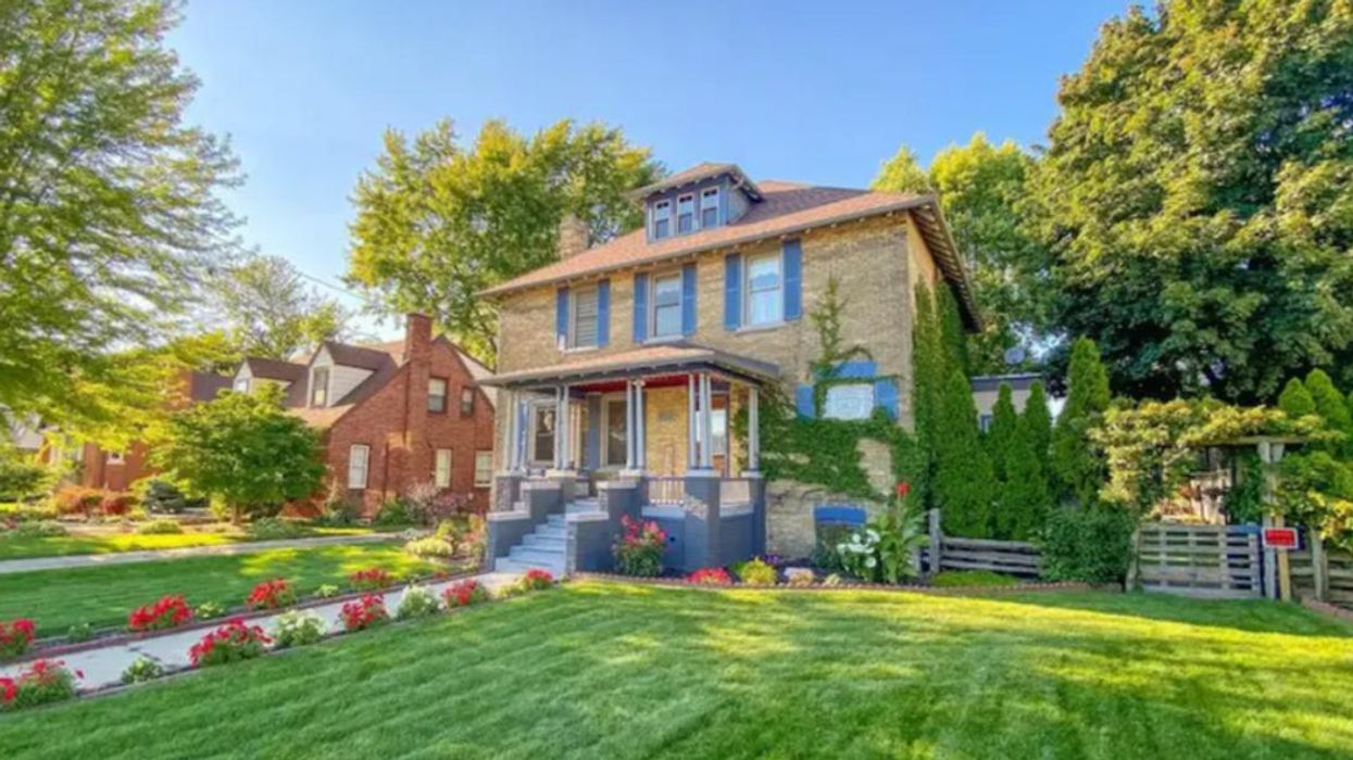 Exterior of the brick home with blue shutters.