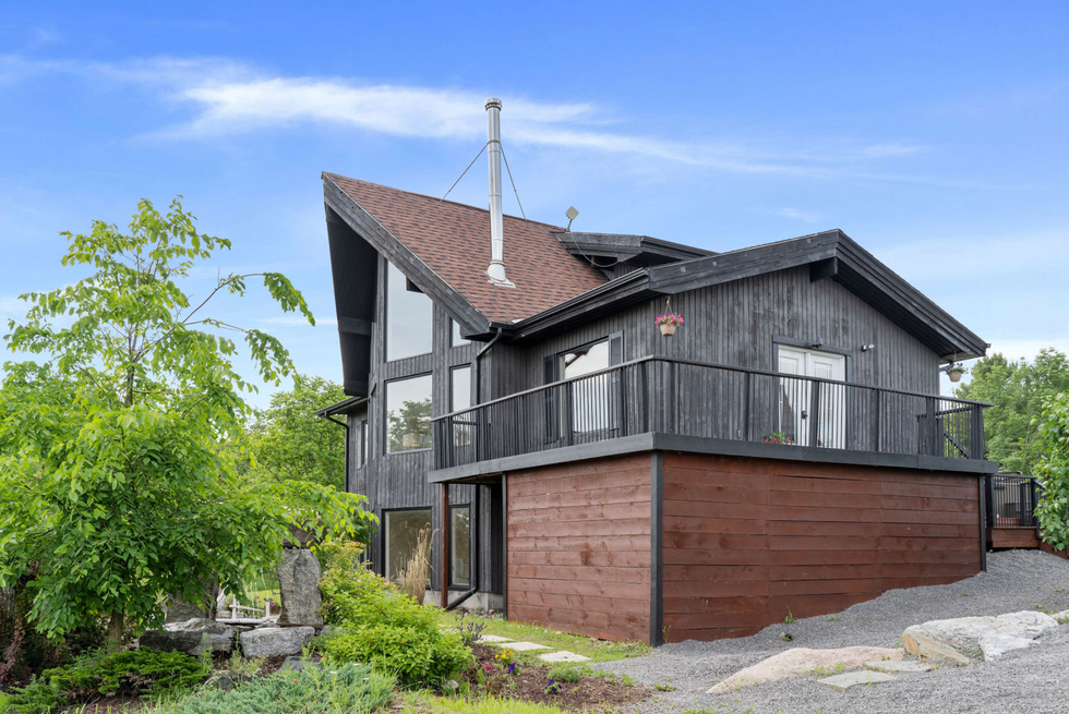 Exterior of the home with a balcony and pond.