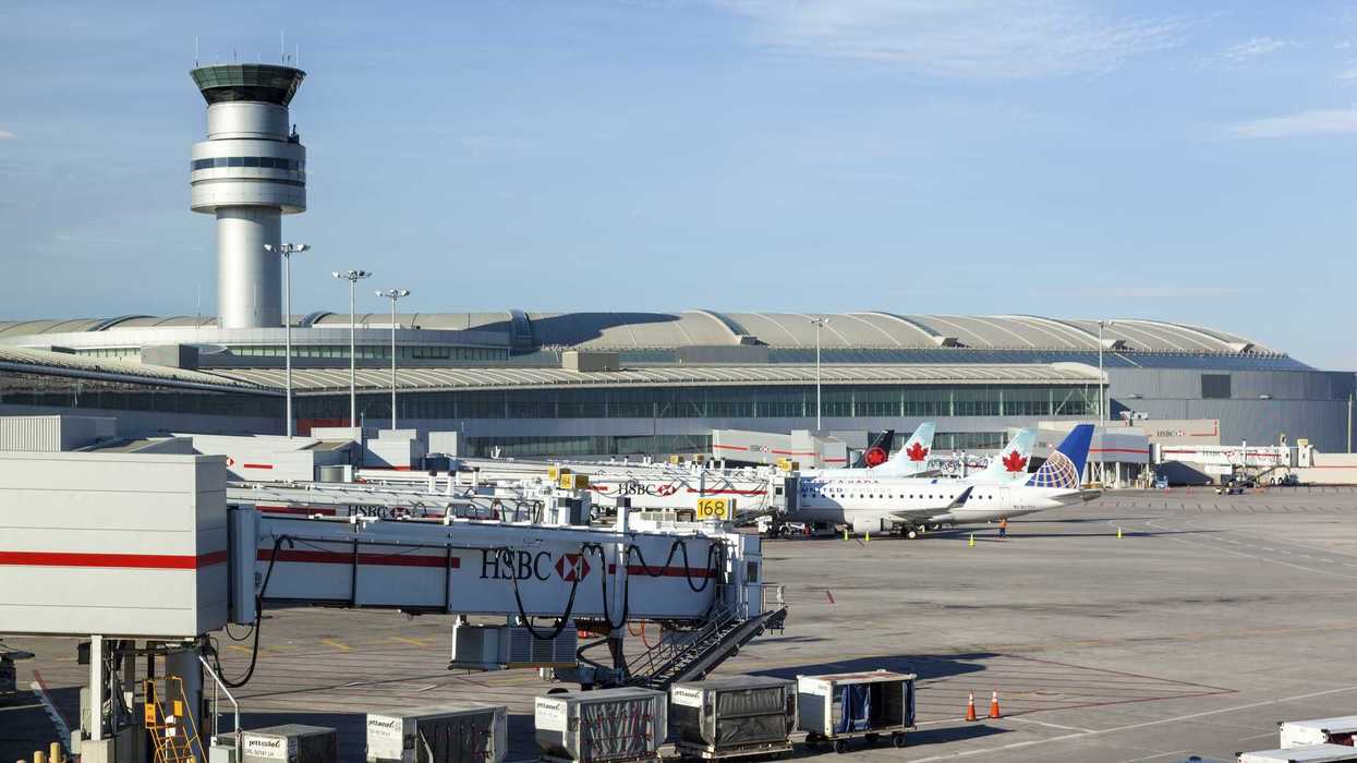 exterior view of toronto pearson international airport with air traffic control tower and airplanes
