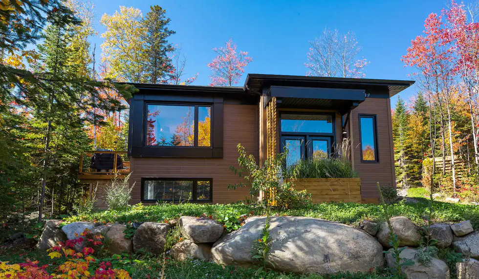 Fa\u00e7ade d'un chalet brun en nature.