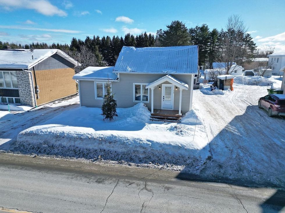 Fa\u00e7ade d'une maison \u00e0 un \u00e9tage et demi grise \u00e0 vendre au Qu\u00e9bec.