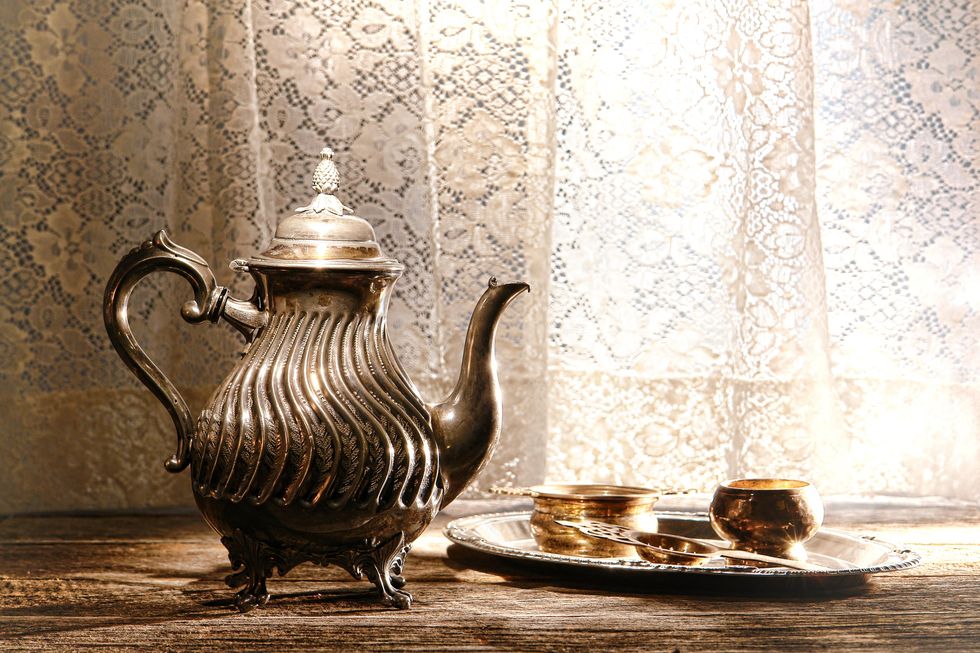 Fancy silver teapot and tea serving tray.
