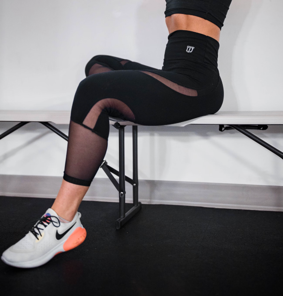 Femme portant des leggings 3/4 de sport avec des espadrilles.