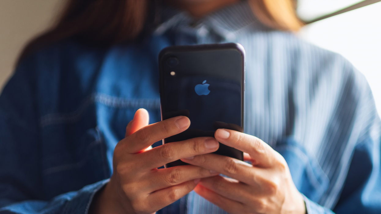 Femme qui tient un téléphone cellulaire dans ses mains.