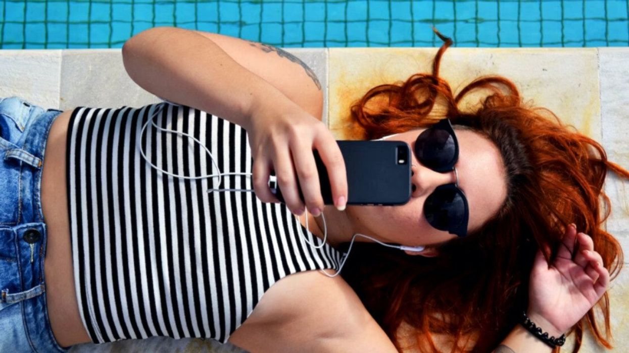Fille qui texte au bord de la piscine.