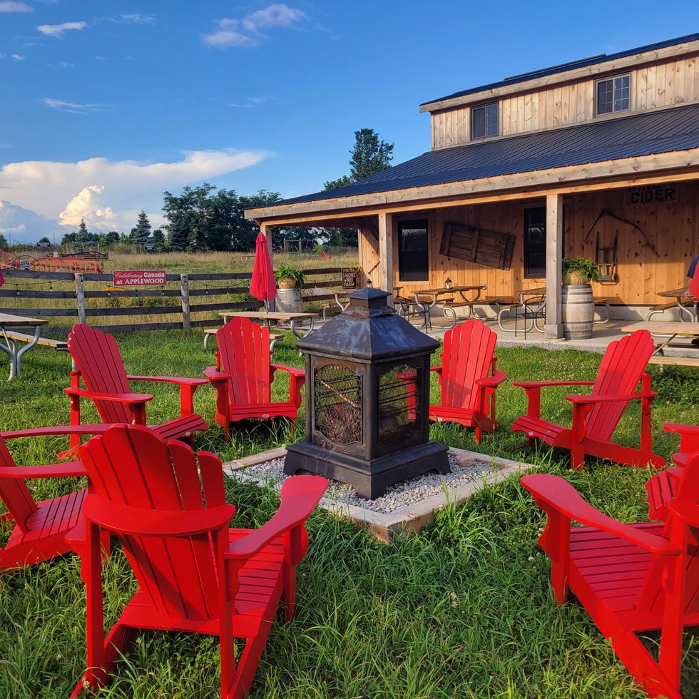 Fire pit with Muskoka chairs at a farm winery patio in Ontario.