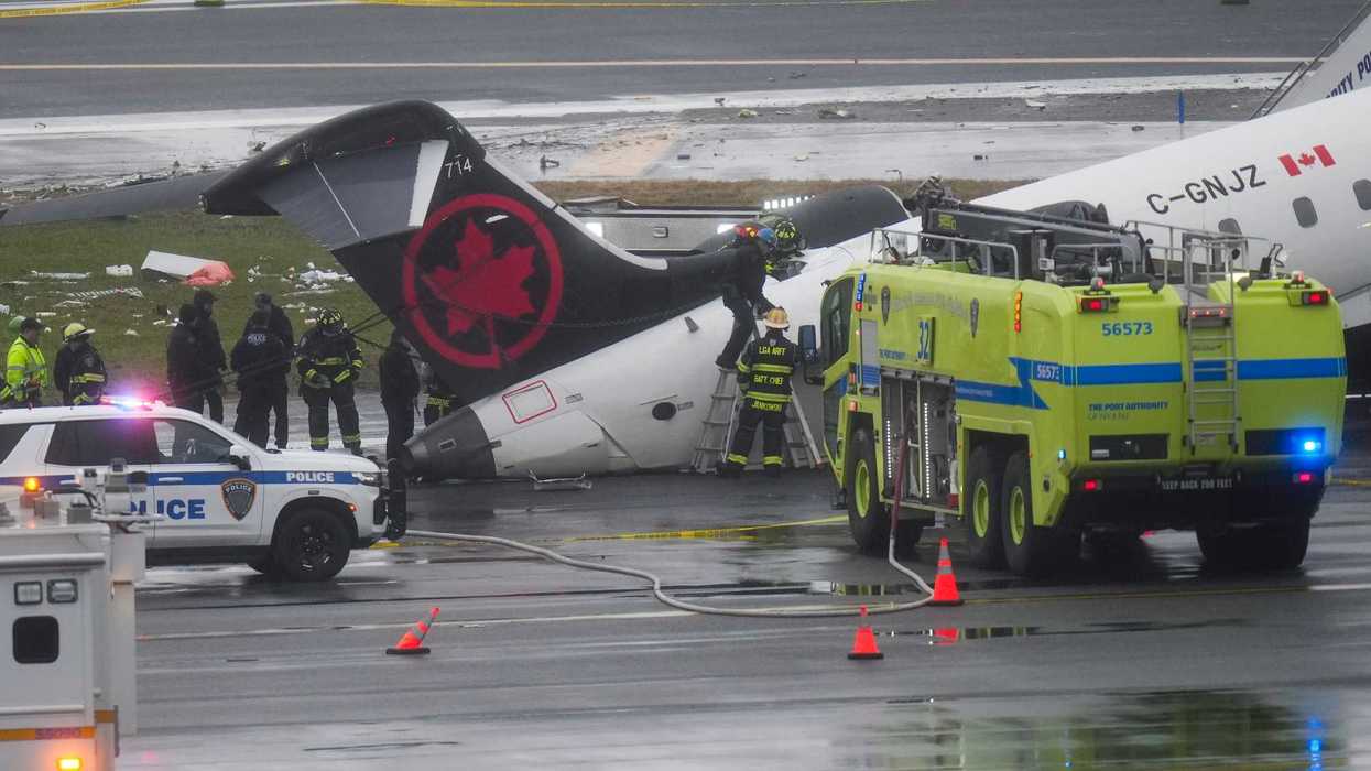 Firefighters and investigators examine the wreckage of an Air Canada plane crash.