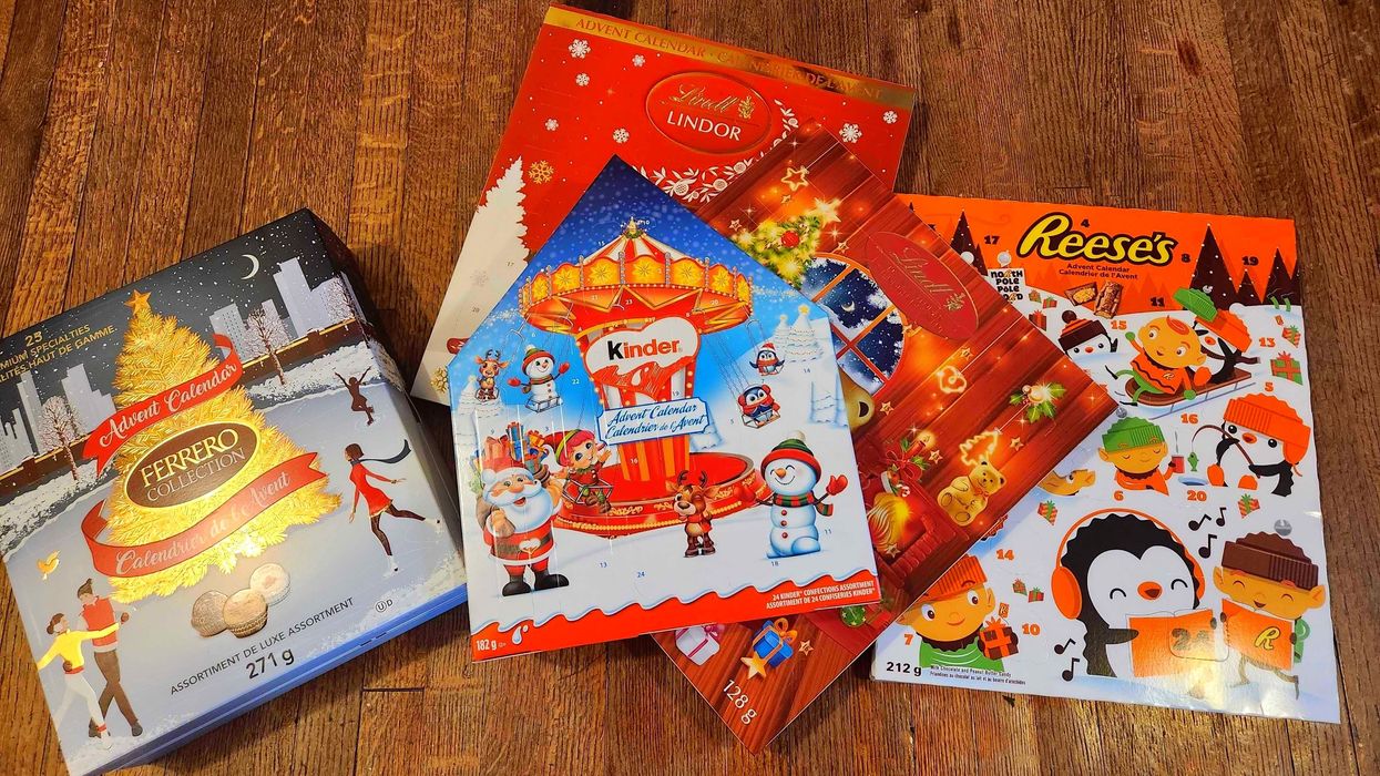 Five chocolate advent calendars against a wooden floor.
