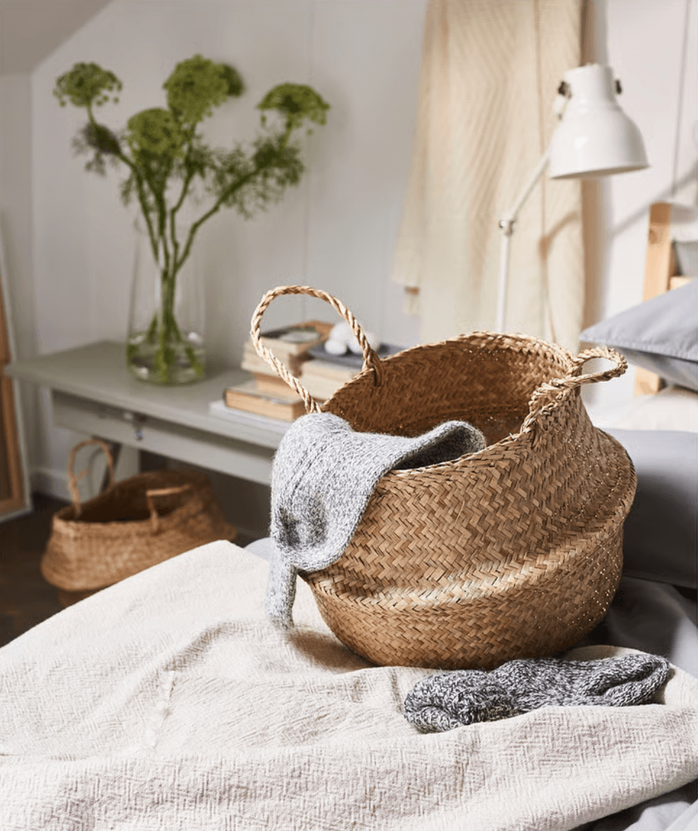 FL\u00c5DIS basket positioned on a cozy bed.
