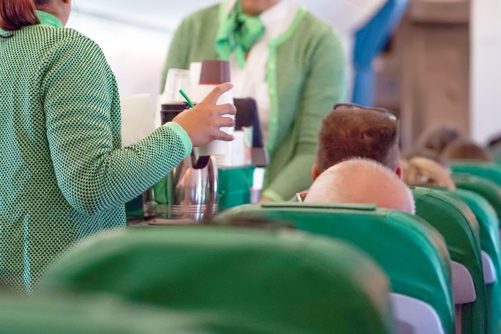 Flight attendant serving a drink.