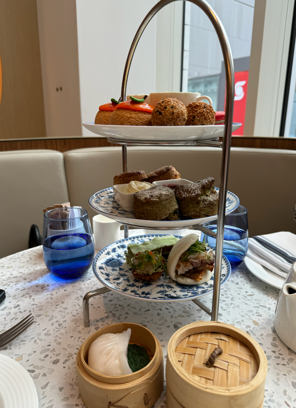 Food on different tiered plates and dumplings in a box.