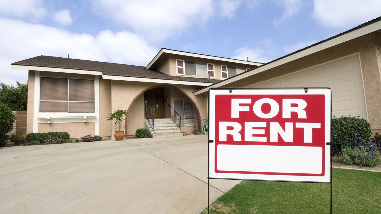 "For Rent" sign in front of a house.