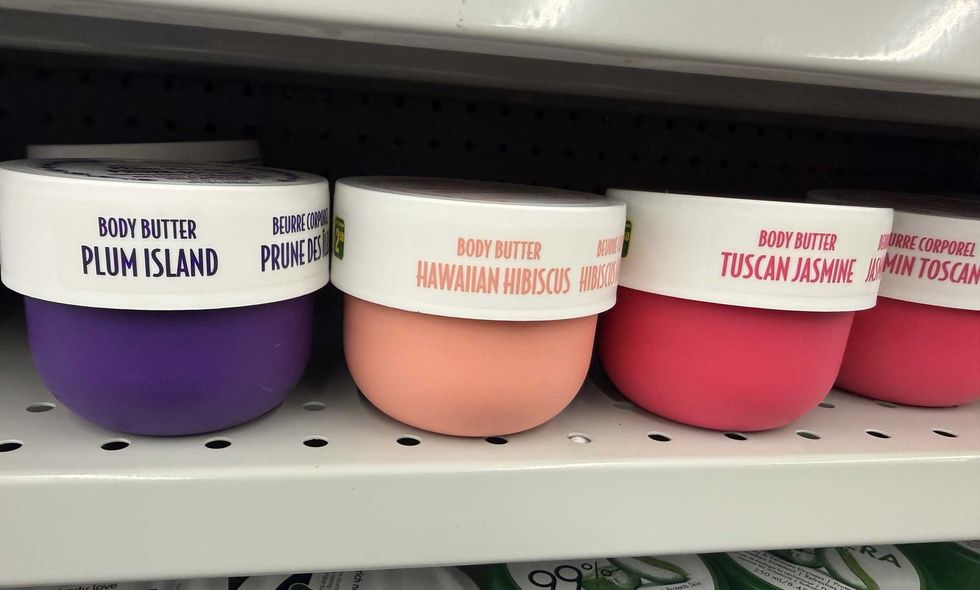 Four colourful tubs on a store shelf with labels reading body butter and then each one having a different scent.