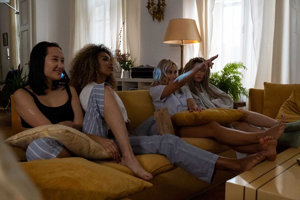 Four friends relaxing on a couch in a share house.
